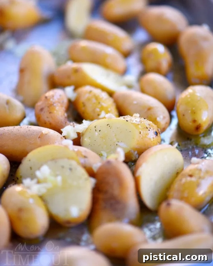 Crispy garlic roasted potatoes piled high on a serving plate, garnished with fresh parsley