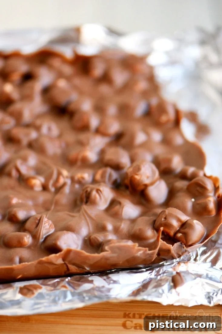 Easy Fantasy Bars in a foil-lined pan, ready to set Fantasy Bars cooling in a foil-lined baking dish, showcasing the simple preparation process.