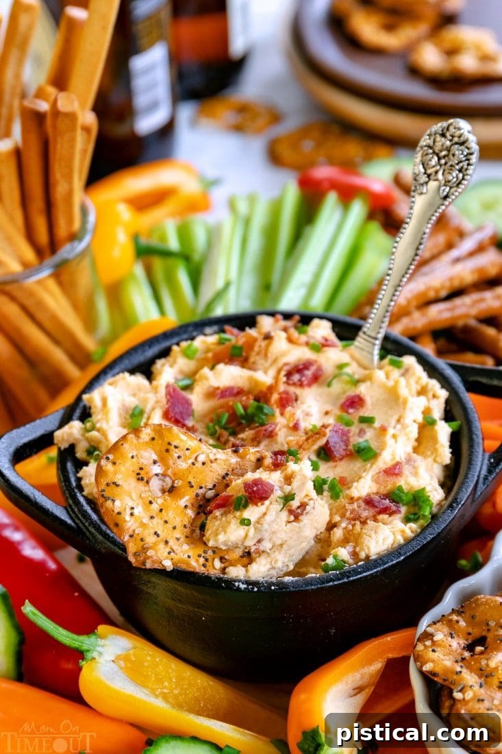 Beer Cheese Dip with bacon crumbles and chives on top, ready to serve