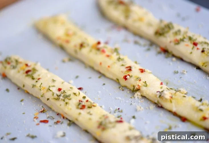 Crispy Garlic Parmesan Breadsticks, seasoned to perfection and ready for dipping. A simple and flavorful side or appetizer. Close-up of freshly baked garlic parmesan breadsticks with seasoning visible