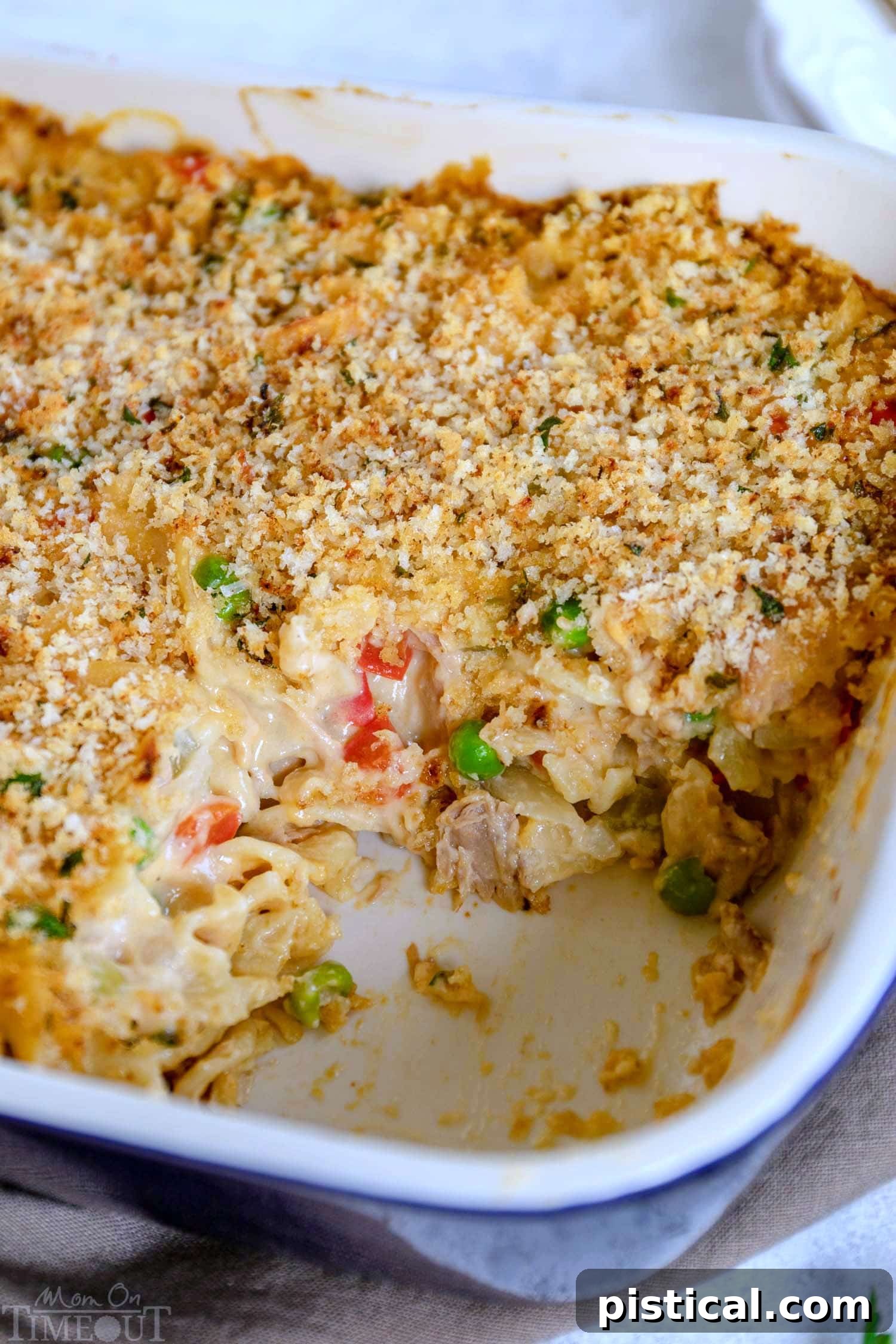 Unbaked tuna casserole with noodles, peas, and a creamy sauce, ready for the crispy topping.