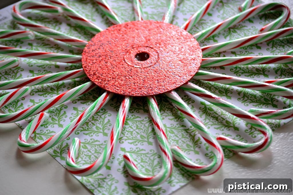 The candy cane wreath flipped over, showcasing the finished arrangement, with a ribbon tied through the center hole for hanging.