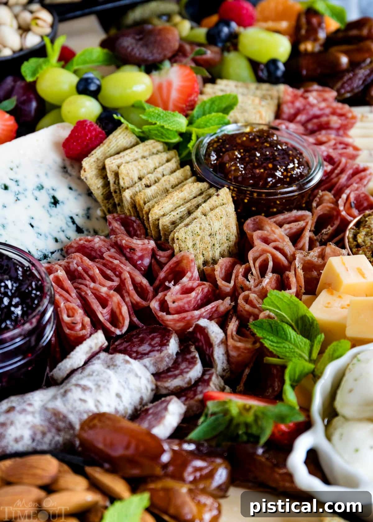 An artfully arranged charcuterie board showcasing a variety of textures and flavors. Close-up of a charcuterie board featuring cured meats, cheeses, bowls of preserves, dried fruits, and almonds.