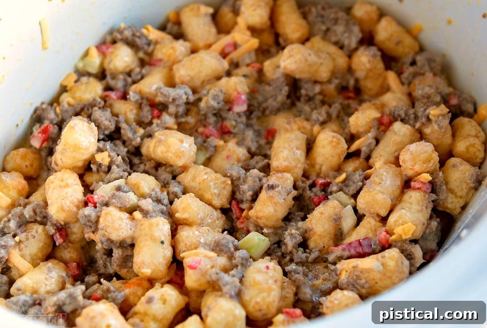 Pre-cooked ingredients for Slow Cooker Tater Tot Breakfast Casserole, ready for slow cooking. Uncooked ingredients for Slow Cooker Tater Tot Breakfast Casserole layered in a slow cooker, including eggs, sausage, cheese, and tater tots.