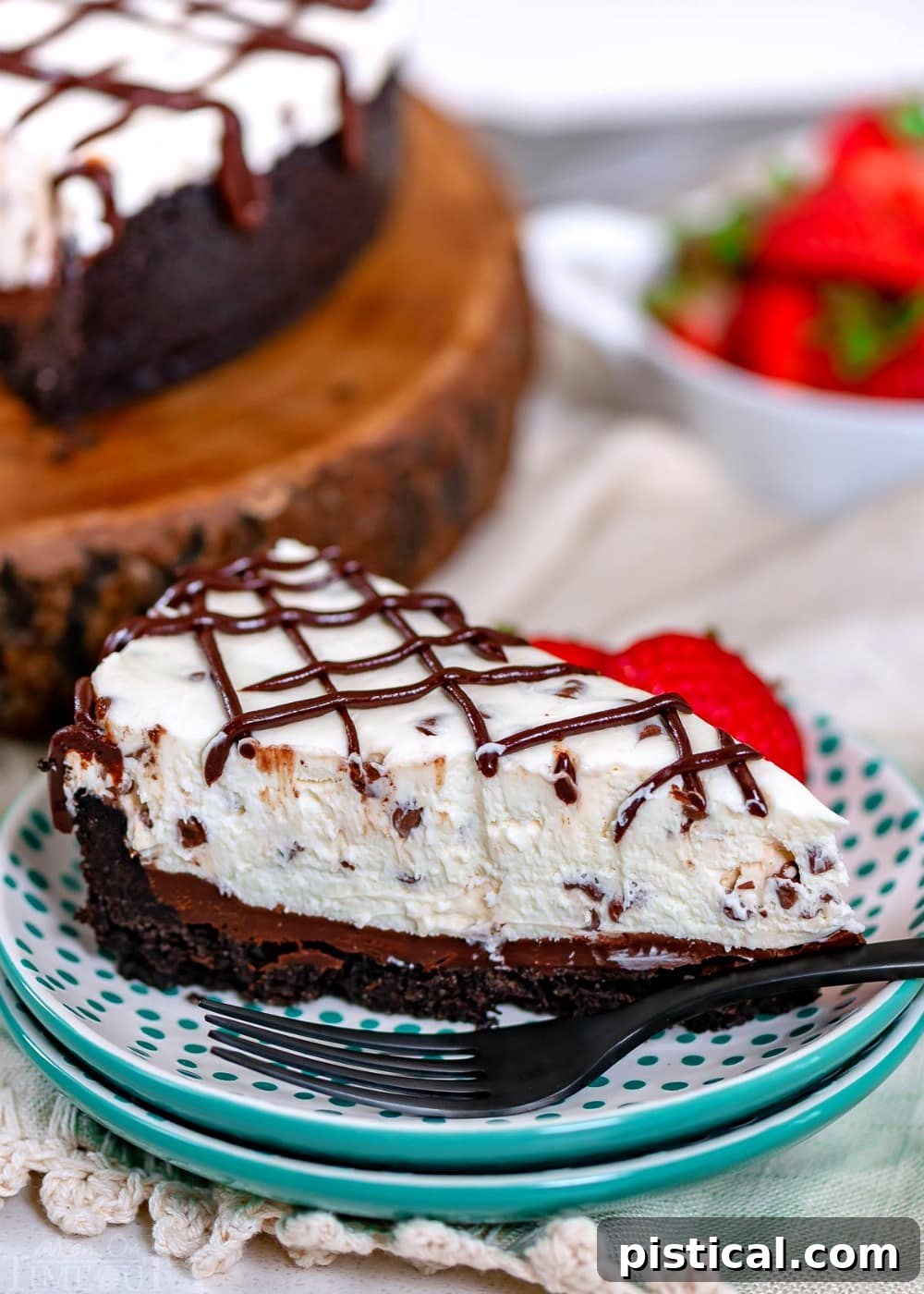 A decadent slice of No-Bake Chocolate Chip Cheesecake, beautifully presented. A thick slice of chocolate chip no-bake cheesecake on a beautiful teal and white plate, ready to be enjoyed.