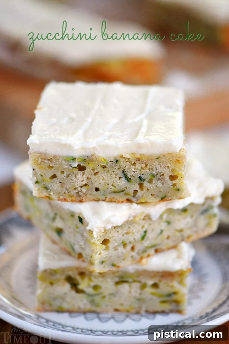 A beautifully sliced Zucchini Banana Cake topped with creamy frosting on a wooden board, with a whole cake in the background.