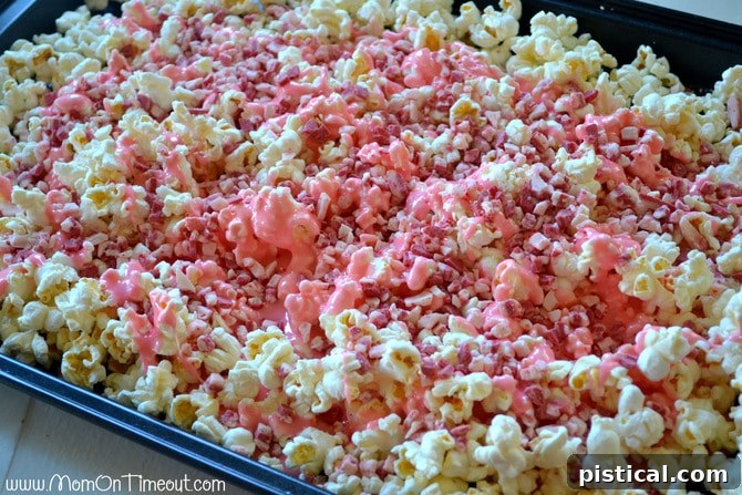 Warm marshmallow mixture being poured over popcorn with Andes Peppermint Crunch chips, ready for mixing.