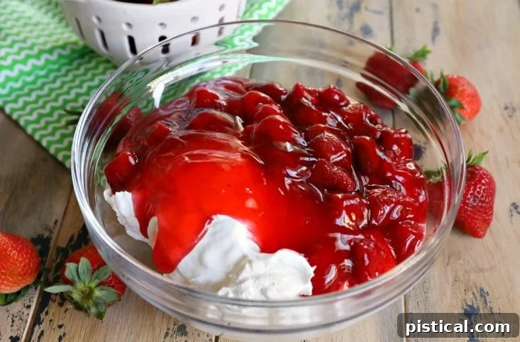 Various ingredients for Strawberry Fluff laid out in separate bowls on a counter, including Cool Whip, condensed milk, pie filling, pineapple, marshmallows, and pecans.
