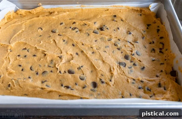 Pumpkin cake batter evenly spread in a prepared baking pan