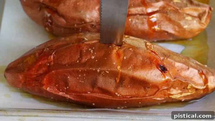 A baked sweet potato with a knife inserted, demonstrating its perfect tenderness.