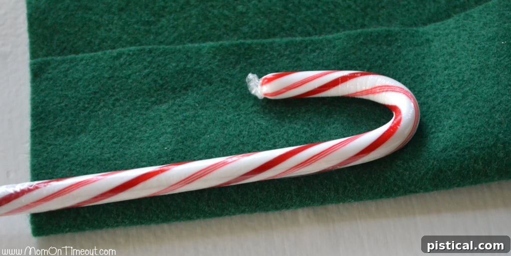 Green felt piece laid out for measuring the desired height of the Candy Cane Christmas Tree, showing where the candy cane trunk will be visible.
