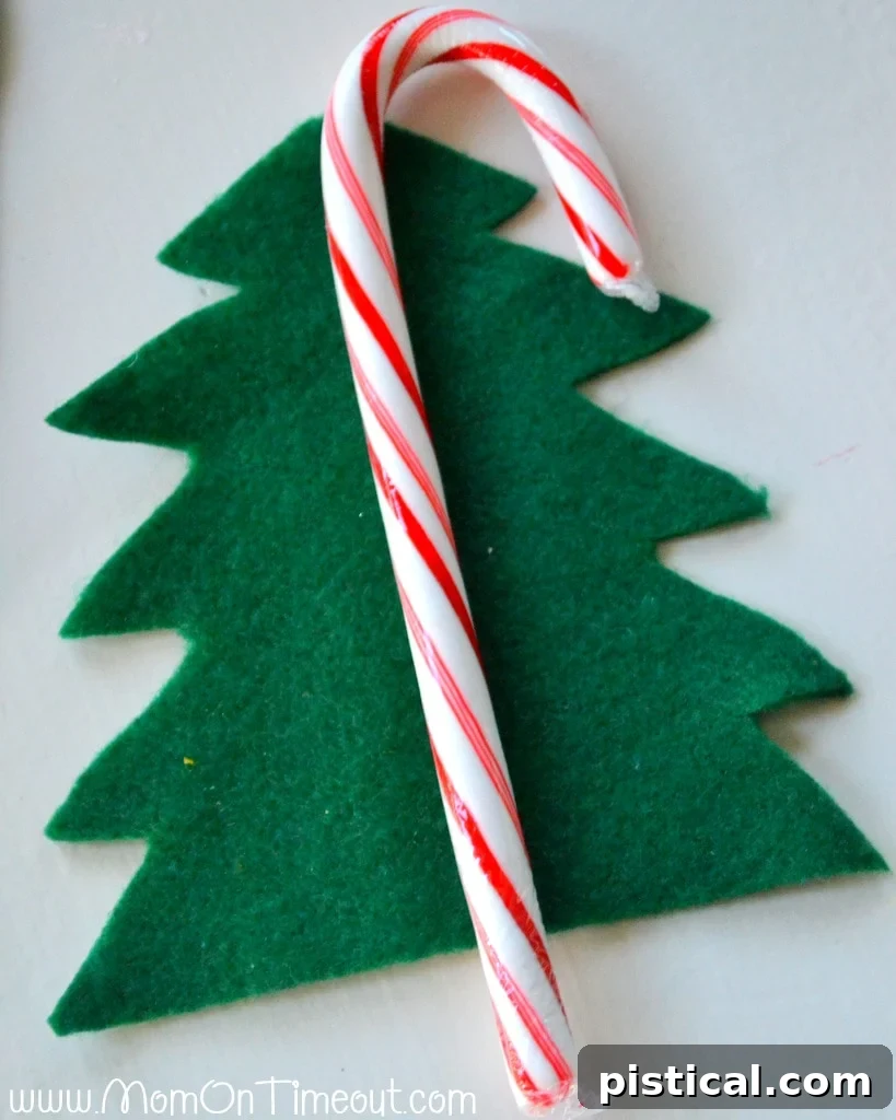 Green felt folded in half, ready to be cut into a symmetrical Christmas tree shape.