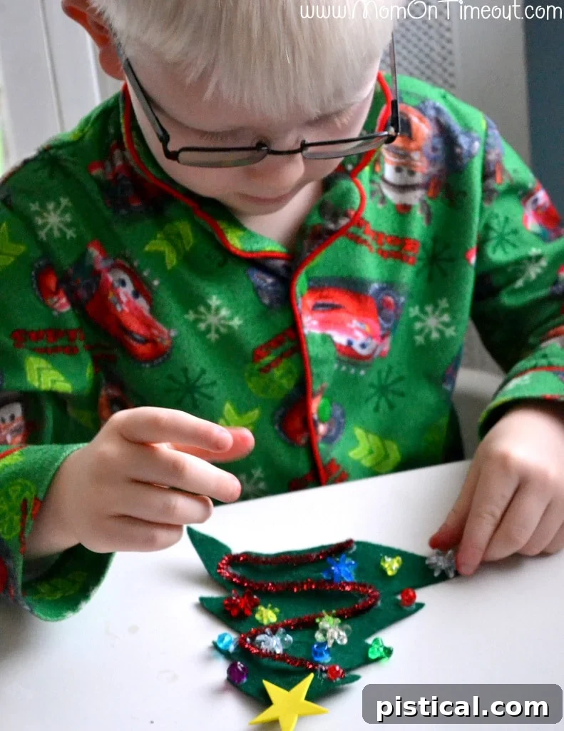 Green felt Christmas tree being decorated with a yellow star and colorful beads, showcasing the creative process.