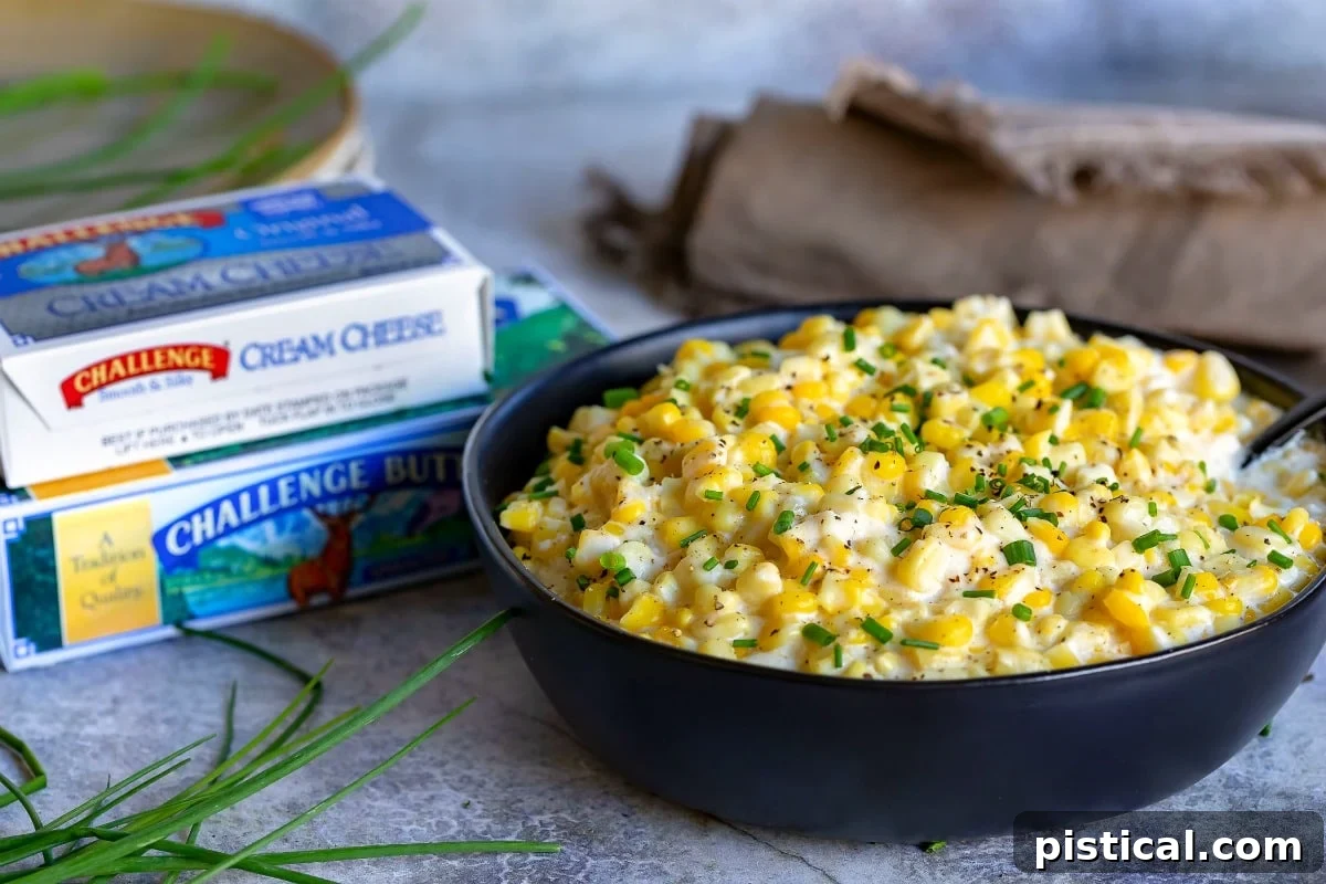 Fresh ingredients laid out for homemade creamed corn, including a block of cream cheese, a stick of butter, and fresh corn kernels, highlighting the quality dairy used.