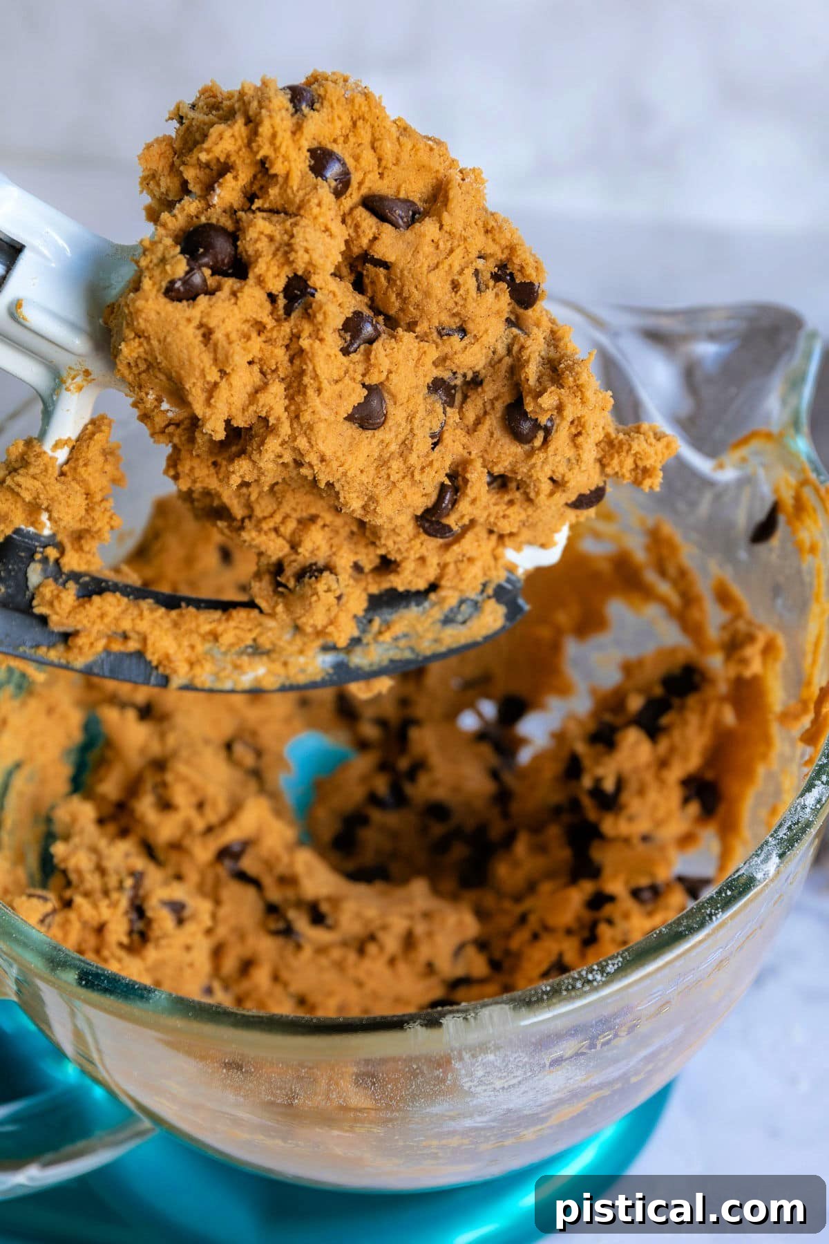These Pumpkin Chocolate Chip Cookies are soft and chewy with loads of pumpkin flavor! Pumpkin pie spice and pumpkin puree work together to create an amazing pumpkin chocolate chip cookie recipe that's just perfect for the holidays! // Mom On Timeout #pumpkinchocolatechipcookies #pumpkin #chocolatechipcookies #cookies #baking #fall #holidays #thanksgiving #christmas Pumpkin chocolate chip cookie recipe dough in a mixing bowl, still on the beater and in the bowl, ready for the next step.