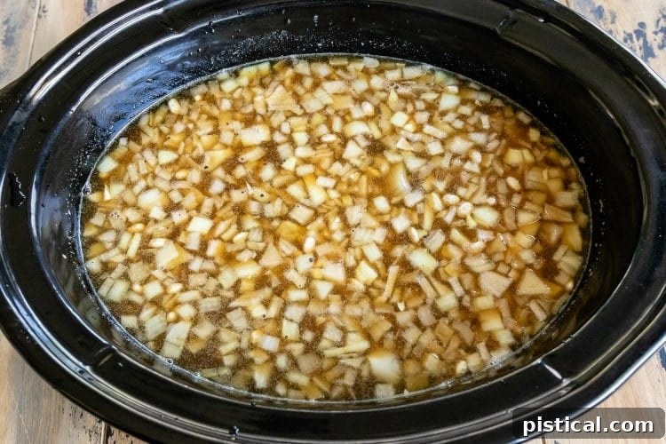 All the crockpot baked beans ingredients loaded into a slow cooker, ready for cooking.
