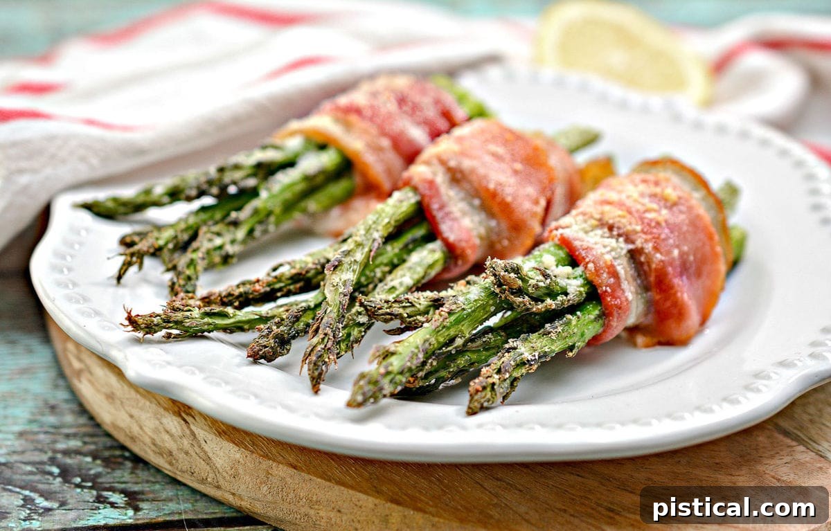 Plated bacon wrapped asparagus recipe on a white plate with a wooden cutting board in the background.