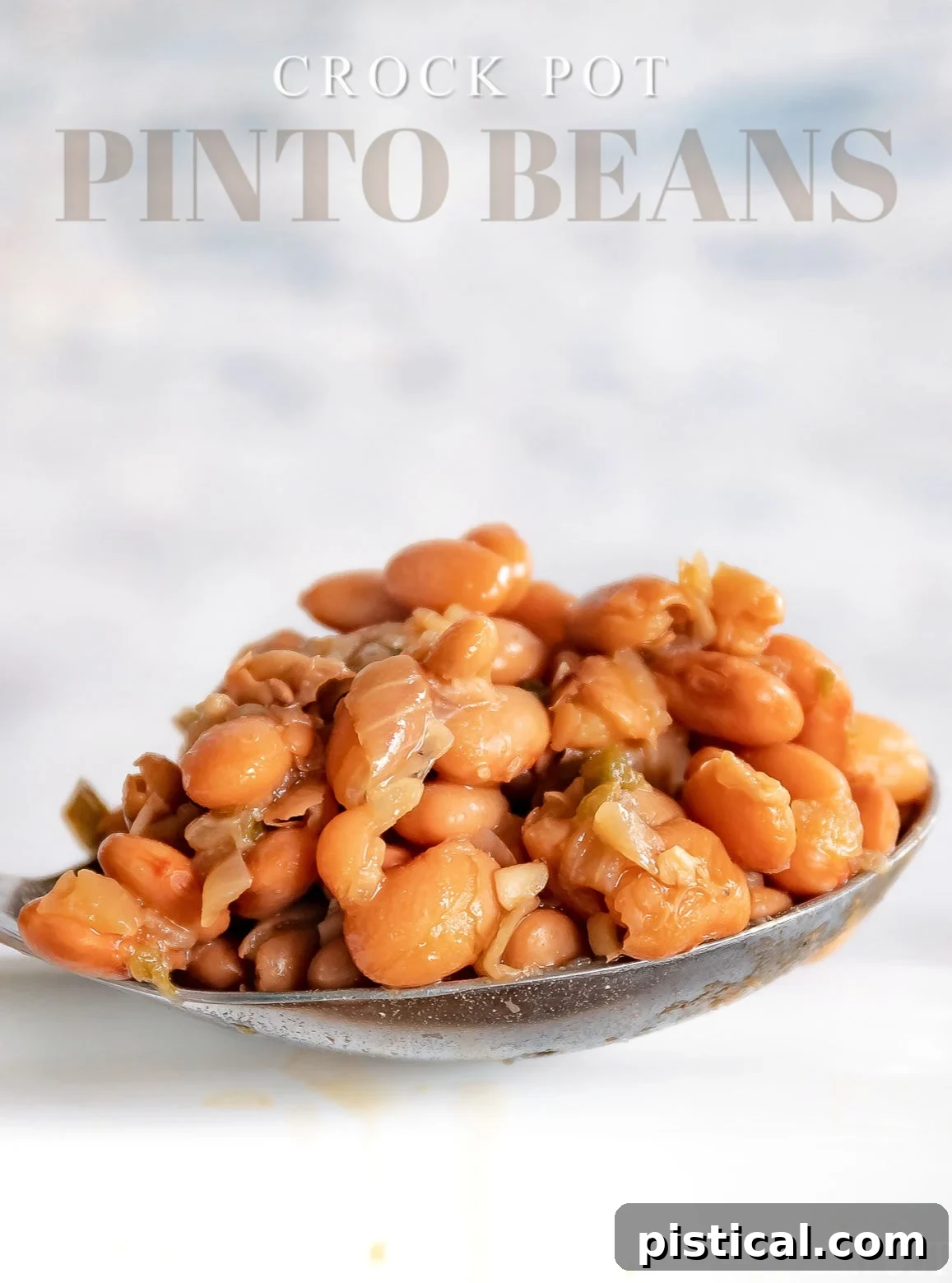 Pinto beans recipe served in a spoon over a white crockpot