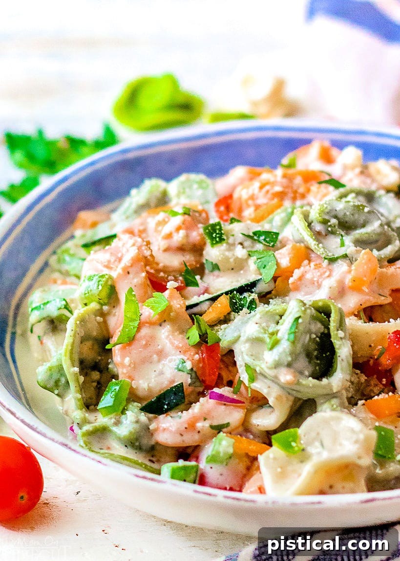 Close-up of a creamy Tortellini Pasta Salad served in a rustic white bowl, highlighting the vibrant ingredients.