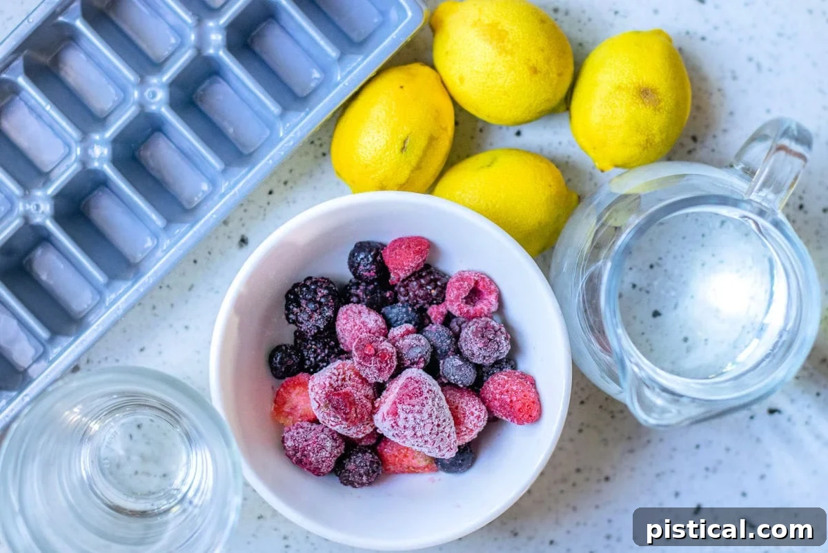 Ingredients for Berry Lemonade laid out on a countertop: fresh lemons, a bowl of frozen berries, and a bottle of syrup.