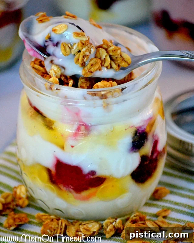 Two hands holding jars of vibrant make-ahead honey vanilla parfaits, highlighting their portability and appeal as a quick, healthy breakfast or snack.