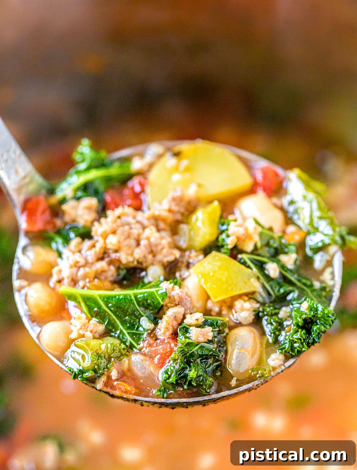 A ladle full of rich, hot Sausage Kale Soup being lifted from the pot, showcasing the hearty chunks of sausage, potatoes, and vibrant green kale.