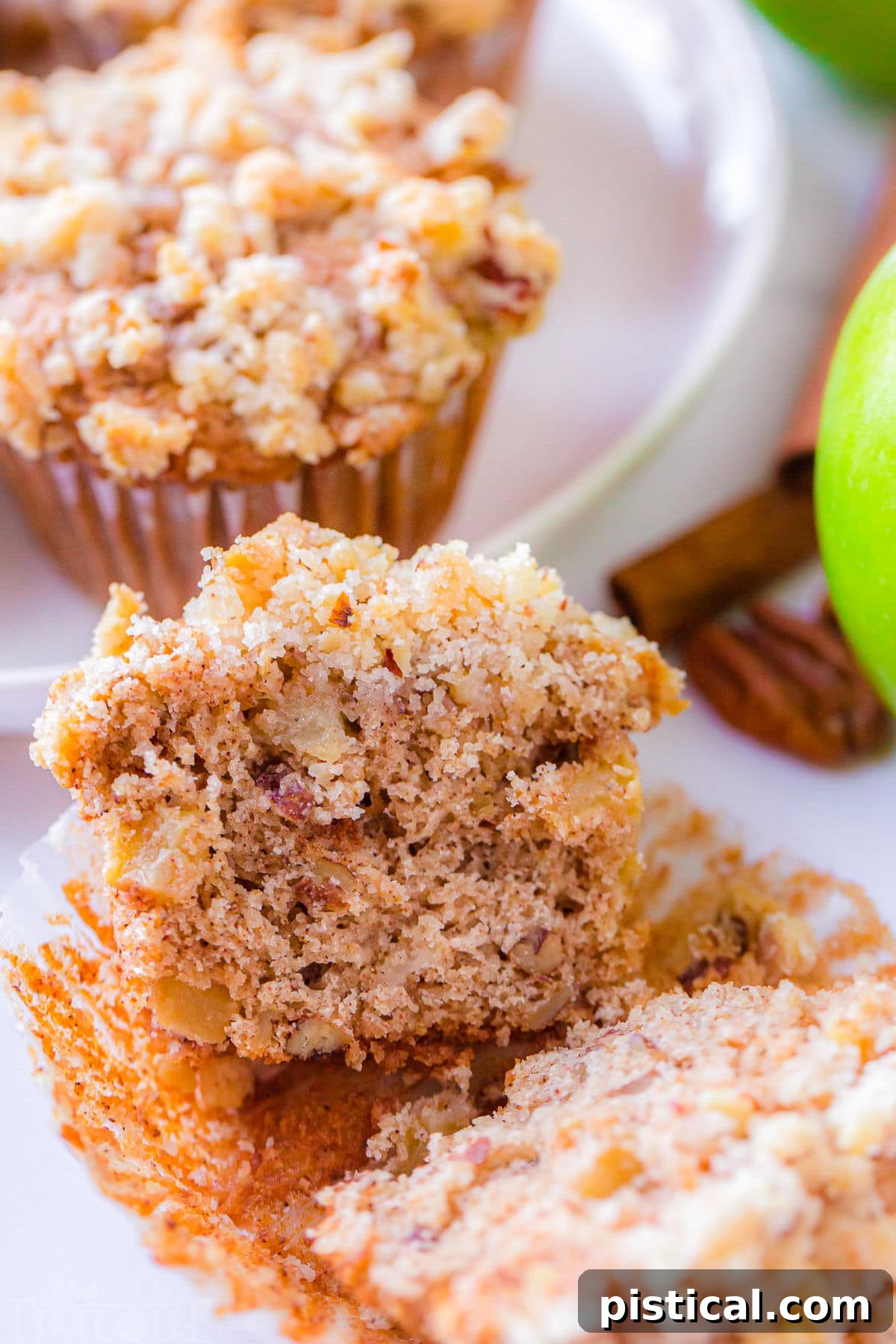 apple muffin split down the middle sitting on it's paper liner