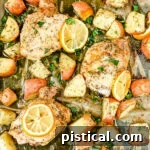 Sheet pan Greek chicken with lemons, potatoes, and fresh parsley, showcasing a vibrant and flavorful meal.