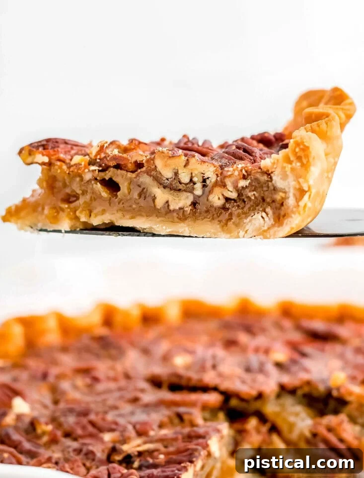 A close-up shot of a perfect slice of maple pecan pie on a pie server, showcasing its rich texture and nutty topping.