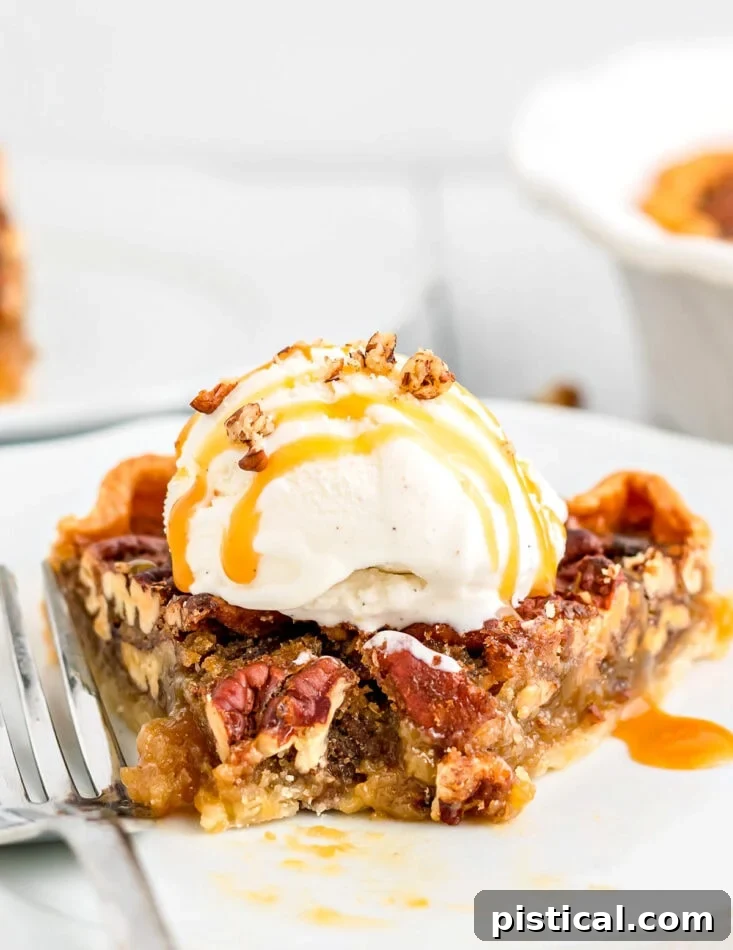 A delicious slice of maple pecan pie on a plate with a bite taken, generously topped with vanilla ice cream and rich caramel sauce.