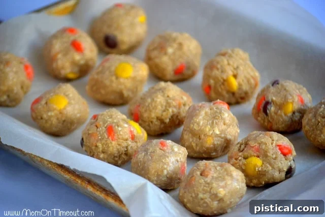 Cookie dough balls arranged on a parchment-lined baking sheet, ready for flash freezing to become freezer-friendly.