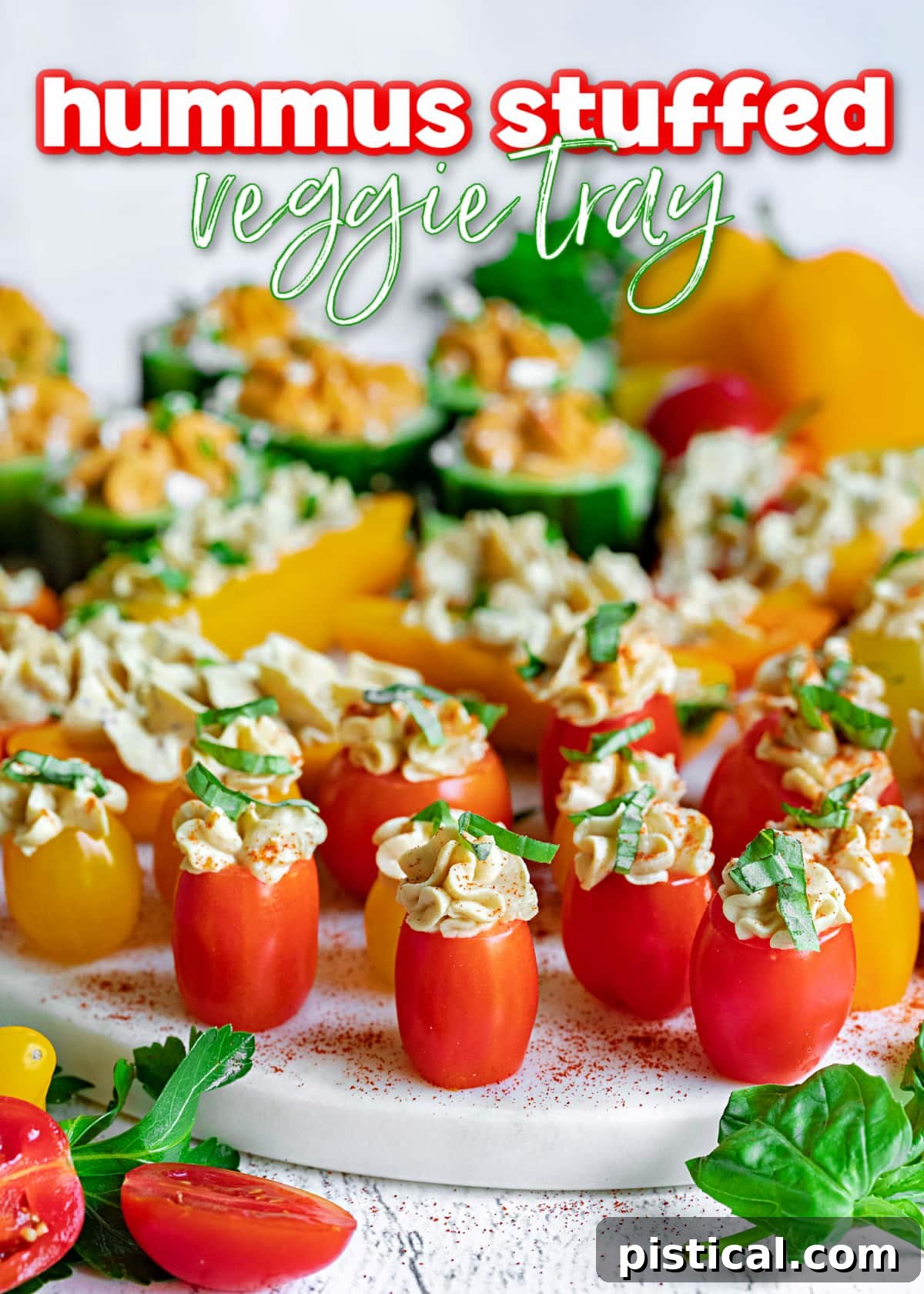 A beautifully arranged hummus stuffed veggie tray on a white marble surface, garnished with fresh herbs, ready for serving.