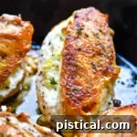 Pan-seared chicken in cast iron skillet stuffed with goat cheese