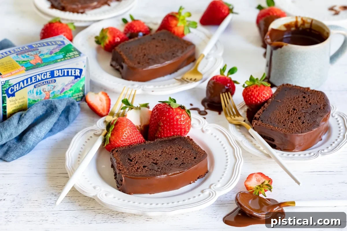 Decadent Chocolate Loaf 7 Individual slices of chocolate pound cake beautifully arranged and served on white plates, each generously drizzled with a rich chocolate glaze and garnished with fresh, juicy strawberries, ready to be enjoyed.