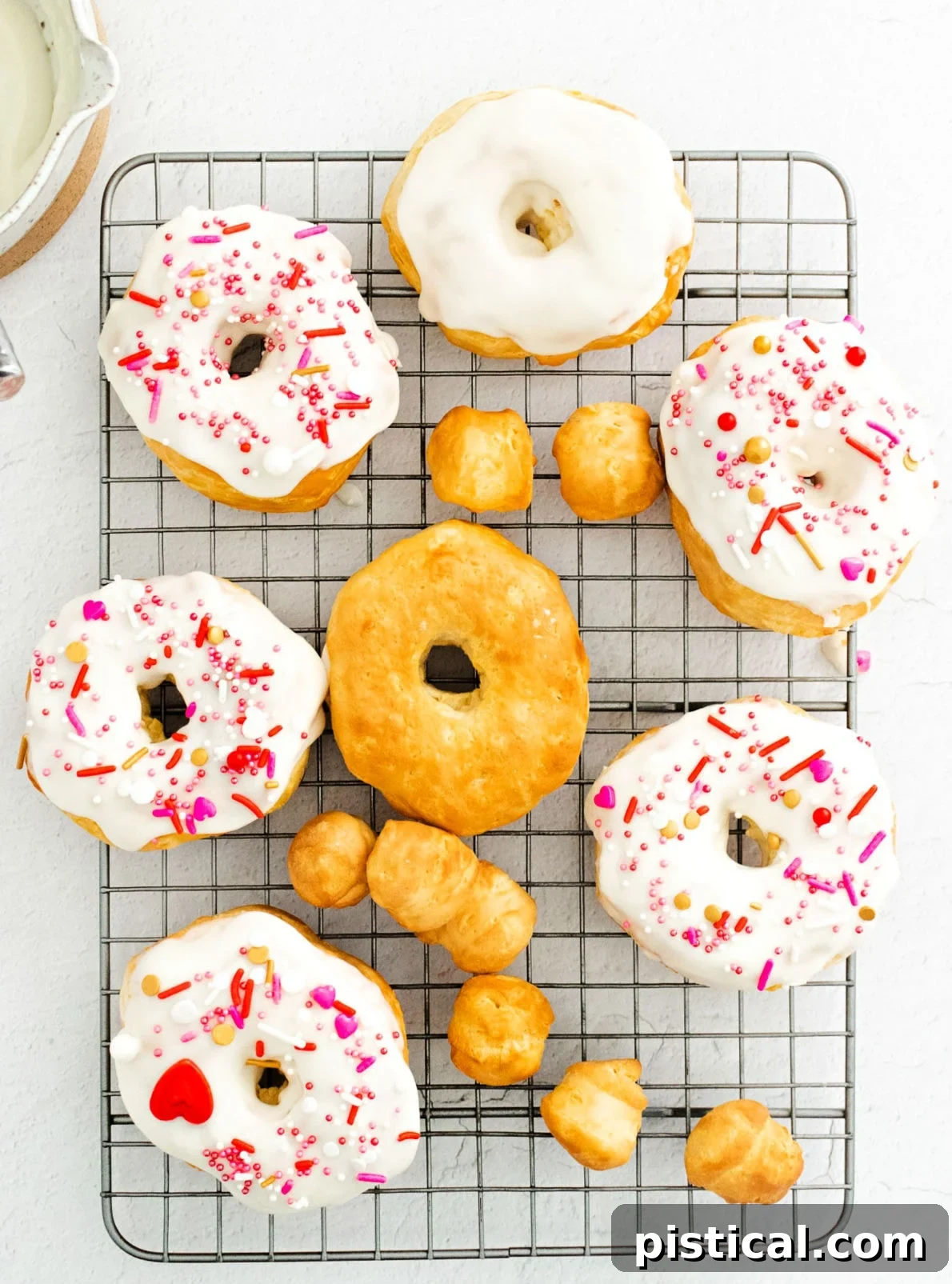 Easy Air Fryer Biscuit Donuts 8 A tempting array of glazed and decorated air fryer donuts cooling on a wire rack, ready to be enjoyed.