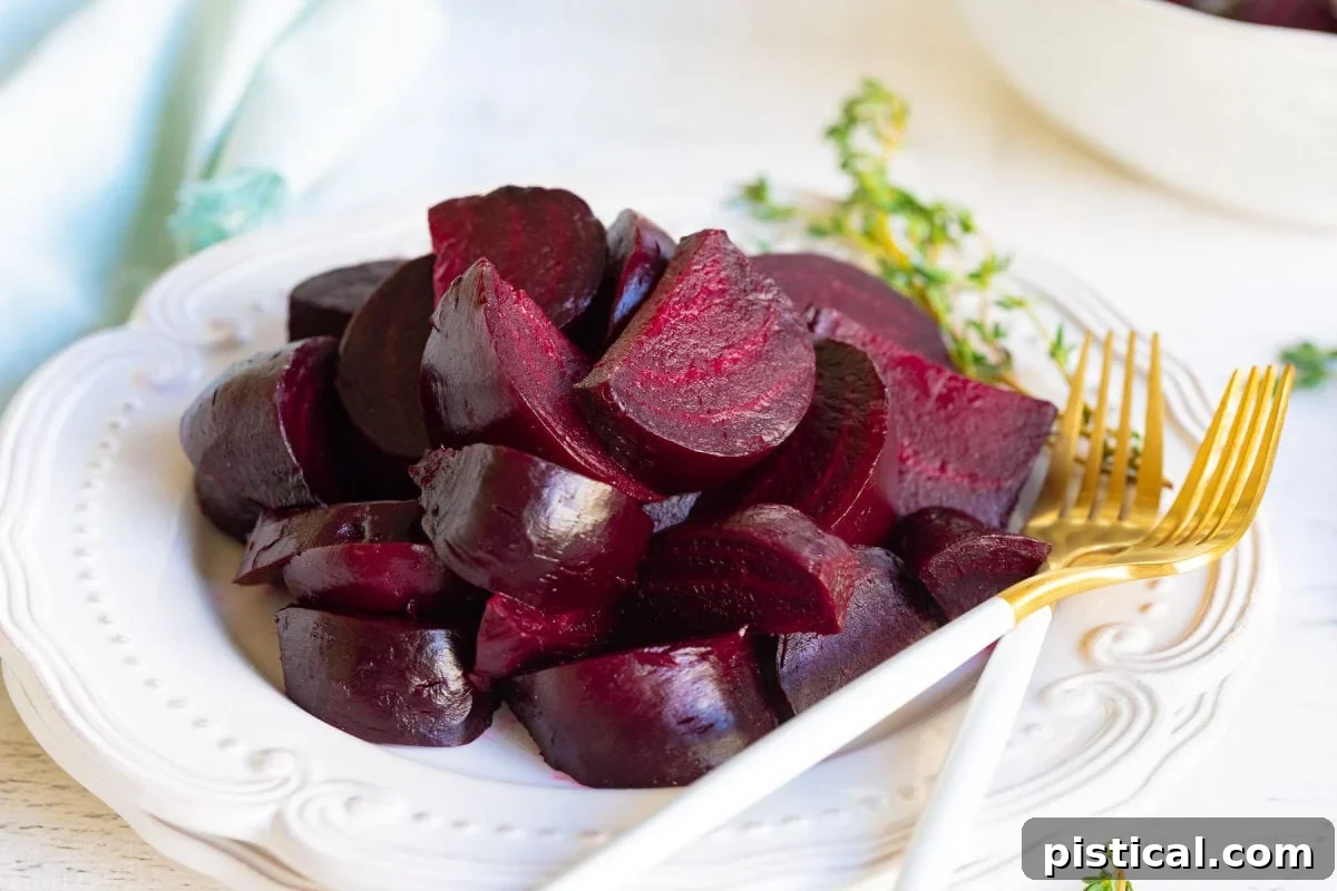 How to Make Perfect Roasted Beets 4 A white plate adorned with roasted beet wedges and two elegant gold forks, poised for an exquisite dining experience.