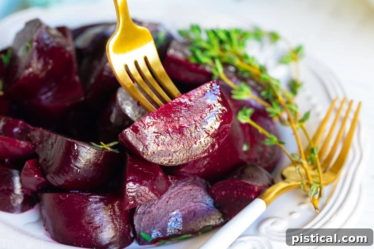 How to Make Perfect Roasted Beets 8 A tender roasted beet being picked up with an elegant gold fork, emphasizing its soft, ready-to-eat texture.