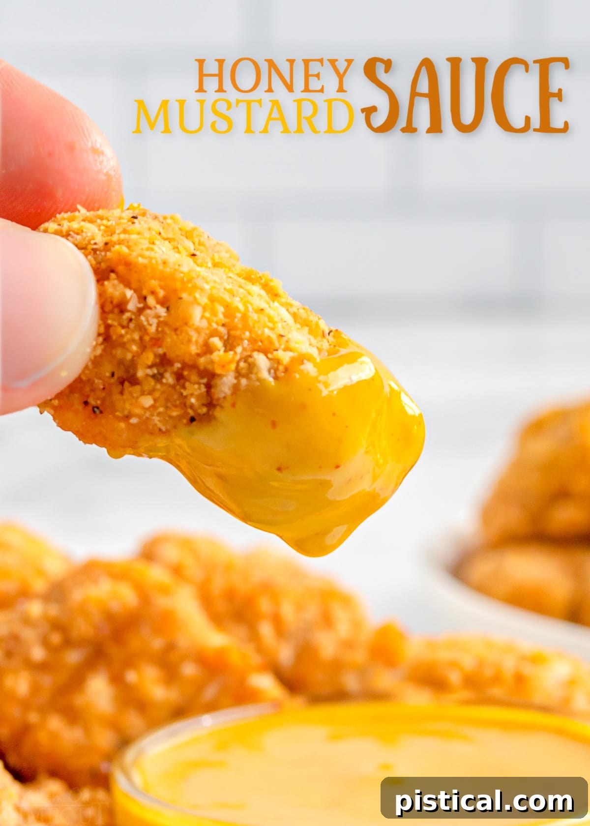 chicken nugget being dipped in honey mustard.