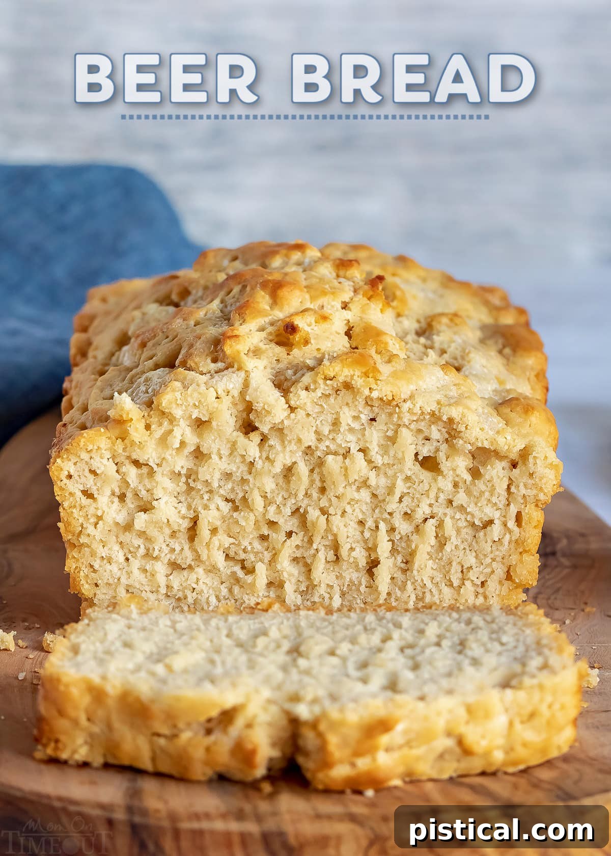 Sliced beer bread on a wooden board with a whole loaf in the background, showcasing its tender crumb and golden crust.
