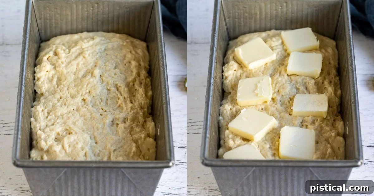 Beer bread batter in a loaf pan, topped with even slices of butter, ready for baking.
