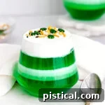 layered green and white jello cups on marble surface.