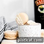 Baileys Macarons 11 A tempting photo of Irish cream macarons positioned beside a bottle of Bailey's Irish Cream, inviting bakers to try the recipe.