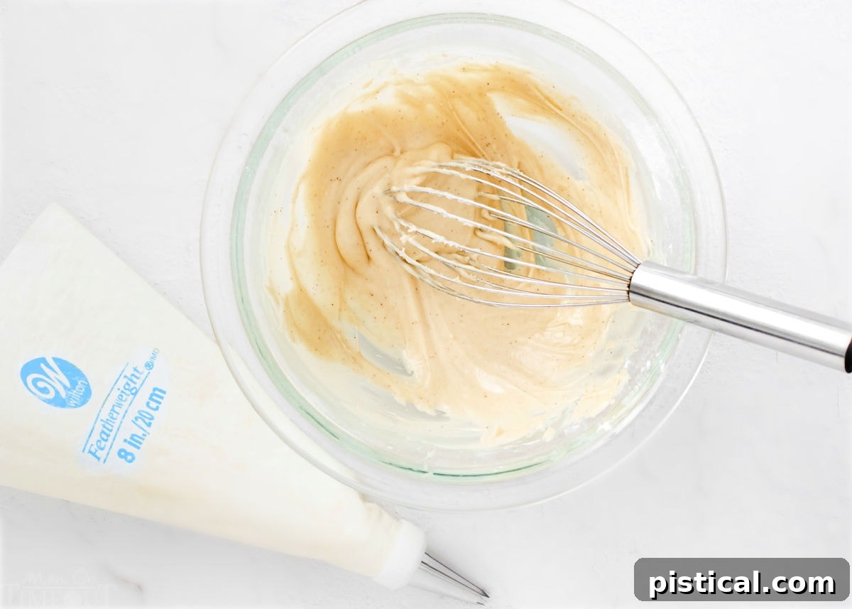 Baileys Macarons 6 Smooth and creamy Irish cream filling in a clear glass bowl, with a whisk resting beside it, ready for macaron assembly.