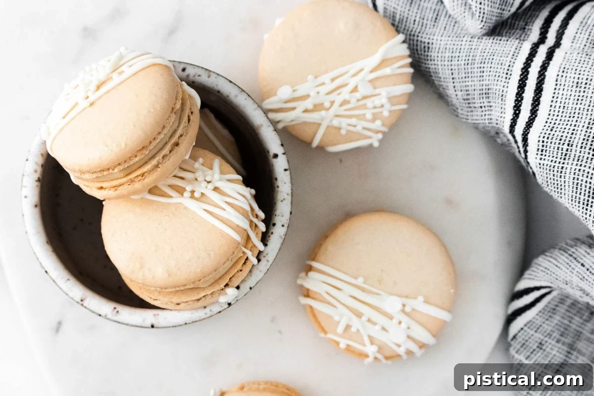 Baileys Macarons 10 A top-down view of beautifully decorated Irish Cream Macarons, artfully drizzled with white chocolate and sprinkled, highlighting their festive appeal.