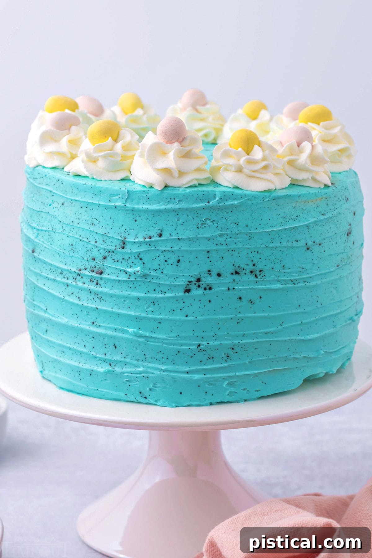whole easter cake decorated with turquoise frosting and cadbury eggs.