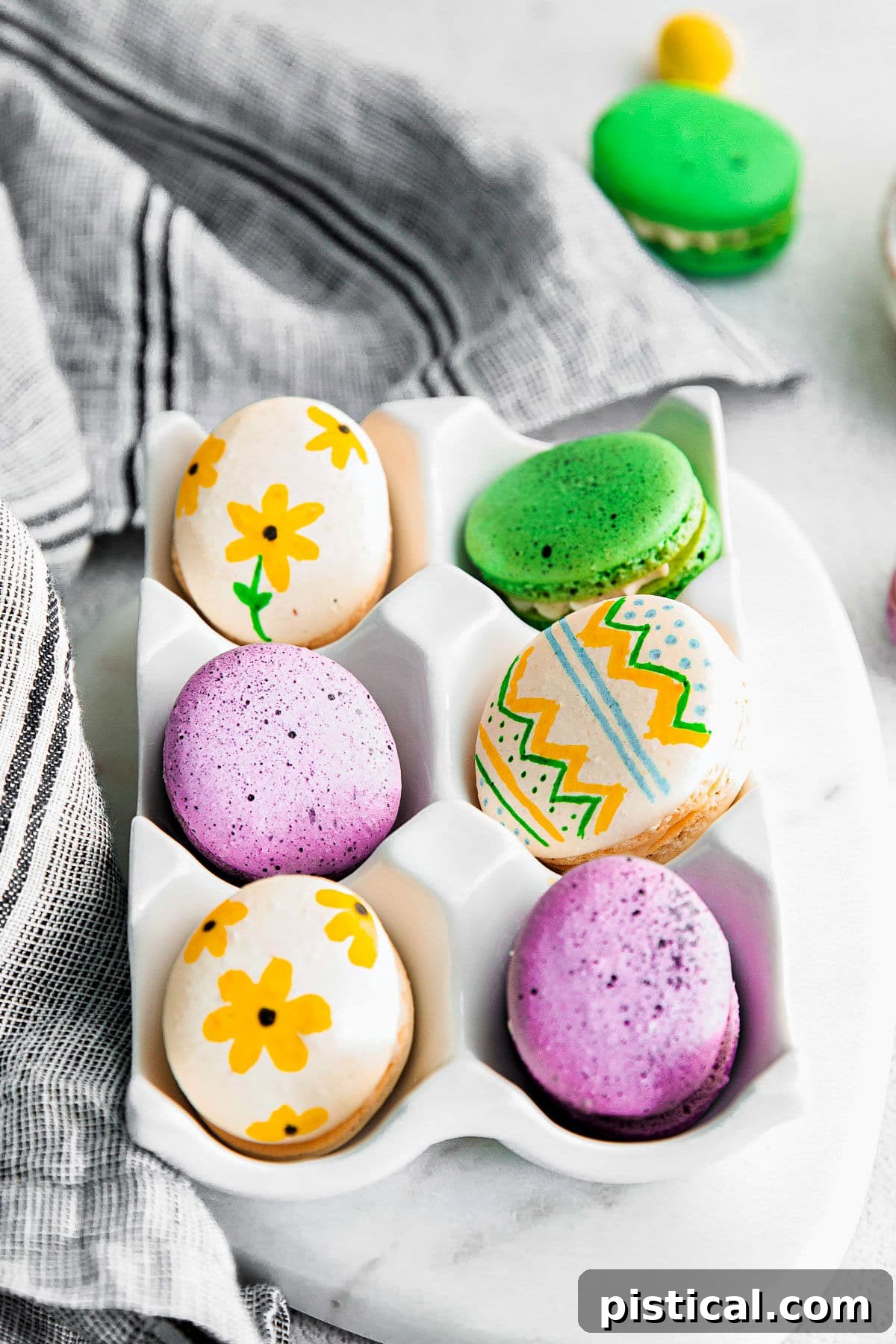 Pastel Easter Macarons 12 6 macarons decorated like eater eggs in white ceramic egg crate.