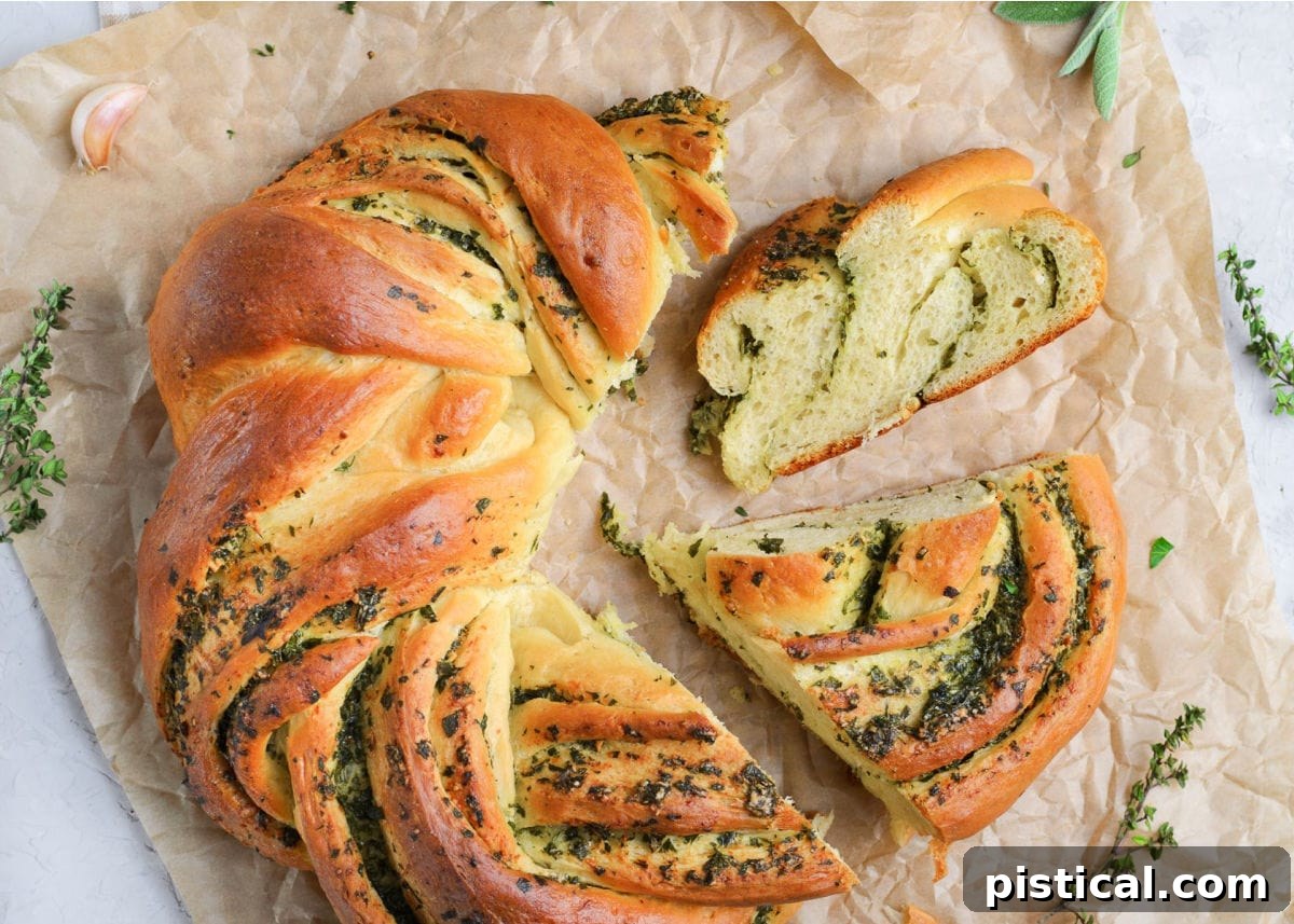 Top-down view of a golden garlic herb bread wreath, with two pieces sliced and pulled away, ready to be served.