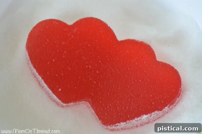 Child coating homemade gumdrops in sugar, focusing on the texture and sweetness.