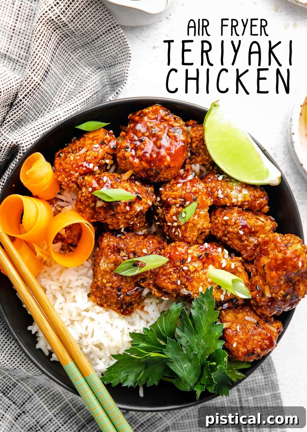 Crispy Air Fryer Teriyaki Chicken served with rice in a black bowl, accompanied by a striped black and white napkin.