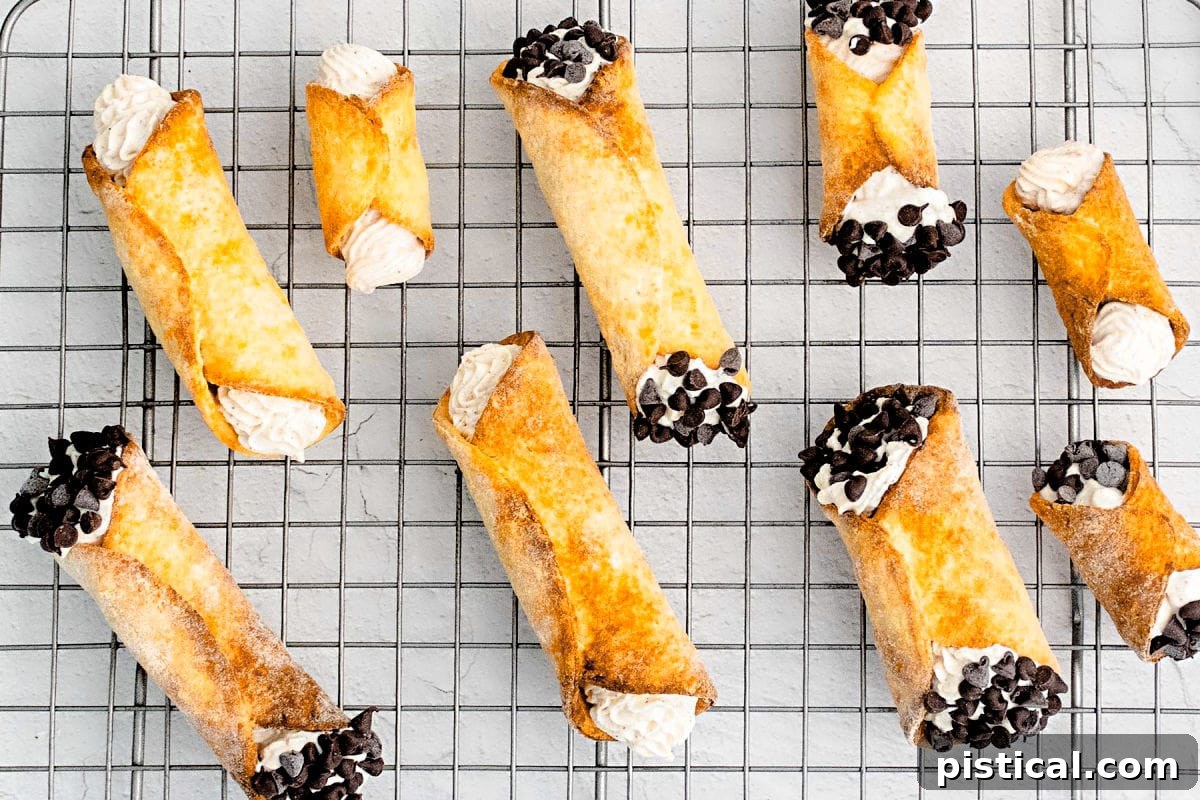 Filled cannolis on a metal rack, ready to eat.